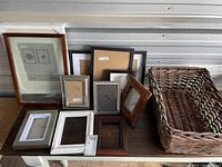 Overview of the assortment of Ikea picture frames in different sizes and finishes with the wicker basket on the right side