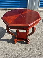 Full view of hexagonal wood side table showing curved legs and lower shelf