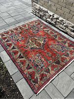 Full view of square rug on stone patio showing overall pattern