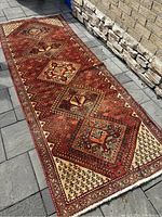 Angled shot of runner laid on patio showing five central medallions and border details