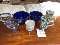 Wide shot showing all items in the lot: vintage blue rimmed glass sugar bowl and creamer, small Pfaltzgraff blue bowl, two Vera Bradley floral print mugs with lids, and two Temp-Tations blue pourable ovenware bowls.