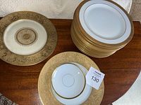 Top view of stacked china plates including Hutschenreuther Bavaria plates and other assorted plates with gold detailing.