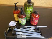 All five bottles of WEN cleansing conditioner with six extra black pump dispensers arranged on table