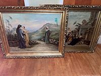 Two ornate gold frames with canvas paintings leaning against wall