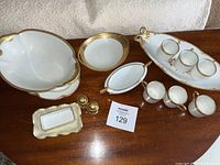 All porcelain serving pieces and demitasse cups arranged on table showing assortment of items included in lot.