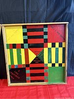 Front view of the African Ludo board game showing the colorful painted wooden surface with game track and inscriptions.