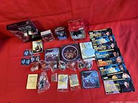 Full assortment of Star Trek and Star Wars collectibles including DVDs, cards, toys, and a porcelain plate displayed on red background