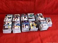 Multiple stacks of 2021-22 Upper Deck Series 1 hockey trading cards bundled with rubber bands on a red background.