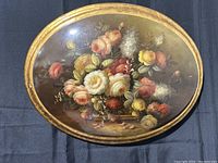 Front view of vintage oval wooden wall art showing detailed floral painting with roses and other flowers.