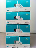 Four boxed DEKCO 2K Wi-Fi Security Cameras stacked, showing product and packaging.