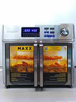 Front view of Kalorik MAXX Air Fryer Oven showing dual French doors with handles, digital display set at 450°F and 20 minutes, and control buttons and knob.