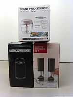 Three boxes shown: Food Processor (manual) on top, Electric Coffee Grinder on left, Electric Grinder Set on right with image of two black grinders and stand.