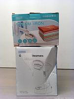 Front view of the two boxed steam irons showing packaging and product images.