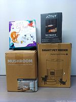 The lot contents showing four boxed items: two automatic pet feeders boxes, one JOTUT pet clipper box, and one ORSDA interactive cat toy box.