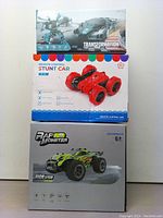 Three boxed remote control toy cars stacked vertically. Top box shows transformation robot car, middle box is red stunt car, bottom box is RAPID MONSTER off-road car.