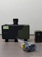 Diivoo WT-11W WiFi water timer main unit with attached fittings and remote control beside it on neutral background.