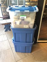 Stack of three blue Rubber Maid tubs with lids containing Easter decorations, seen externally.