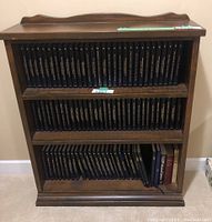 Full view of three-shelf bookcase filled with black Bantam hardcovers and additional volumes