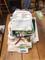 Stack of various kitchen tea towels, some with printed recipes and designs, folded on a wooden table.