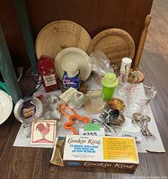 Photo of kitchen tools on white surface including Pyrex measuring cup, Kitchenaid hand mixer, wooden cutting boards, metal spoons and other baking accessories