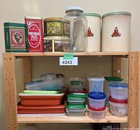 Shelf display showing vintage metal tins including Eaton's Premium Plus and others, glass jar, and an assortment of plastic food storage containers in various sizes and colors.