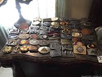 Full overhead view of metal belt buckles spread across wooden table