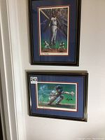 Two framed art prints featuring Atlanta Braves players Otis Nixon and Greg Olson hung on a wall.
