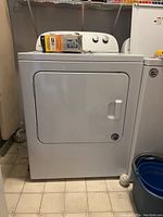 Front view of white Whirlpool dryer, showing door and control panel on top.
