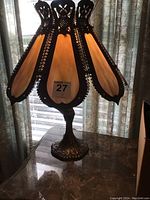 First lamp with metal base and opaque cream stained glass panels, ornate metal trim and stand, photo showing detail of shade and base.