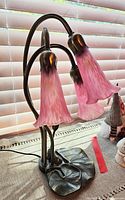 Full view of the metal lilypad lamp with three pink glass shades, showing the entire lamp and base.