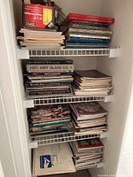Four shelves densely packed with assorted craft books and magazines primarily focused on stained glass, glass techniques, and kaleidoscopes.