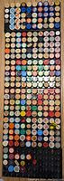 Overhead photo showing a large collection of vintage filmstrip cannisters arranged tightly in rows, varying colors with labels on tops.