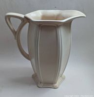 Side profile of the cream coloured Royal Minton pitcher showing elegant vertical panel design and curved handle.