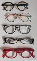 Five pairs of prescription glasses laid out in a single column with various frame styles and colors shown clearly.