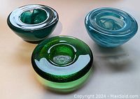Set of three Kosta Boda candle holders with heavy glass, various textures and swirl patterns in green and blue colors.