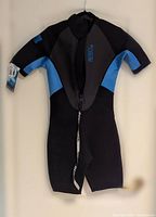 Full view of the Body Glove men's wetsuit in size Medium. Showing front zipper, short sleeves and short legs. Colors are black, blue and grey.