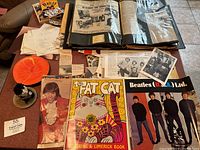 Overview of fan collection including Beatles poster, Fat Cat book, small doll, photographs, and scrapbook albums with clippings.