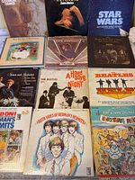Overview photo of all vinyl records laid out showing various classic rock albums, including The Beatles (Help!, A Hard Day's Night), Star Wars soundtrack, Herman's Hermits, Lovin' Spoonful, Simon and Garfunkel, and others.