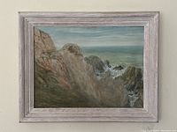 Full view of original framed oil painting depicting coastal cliffs and ocean waves