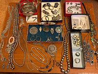 Full overview of all silver jewelry pieces on wooden surface
