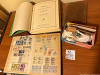 Open Scott's Specialty Album of Japan showing mounted stamps on album pages with protective translucent sheets.