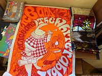 Full view of orange and white Alice in Wonderland poster laid on table