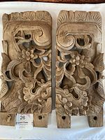 Two vintage Asian wooden wall carvings side by side on white background, showing intricate bird and floral designs carved in natural wood.