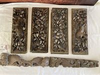 Six carved wood panels laid out showing the four large bird and floral panels on top and the two smaller dragon panels below