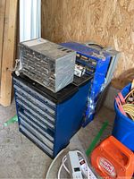 Image showing five stacked hardware caddies with multiple plastic drawers in a garage setting