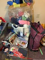 Basket on top of large plastic bag filled with multicolored yarn skeins, knitting needles, and craft ribbons arranged around.