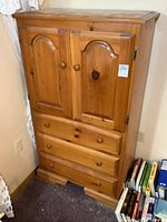 Solid pine dresser front view showing two cupboard doors and three drawers with wooden knobs.