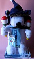 Front view of Snoopy stuffed toy dressed in blue wizard hat and cape, holding maracas, visible tags and original packaging.