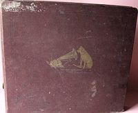 Front cover of a burgundy/brown album with gold His Master's Voice logo featuring a dog listening to a gramophone. Shows surface wear and discoloration.