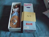 Barbie Collector's Edition Doll Series II in original white box with blue checkered design and Little Debbie branding, doll dressed in white blouse, blue gingham skirt, and tan hat with blue ribbon, 12 inches tall.